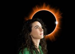 Mujer frente a un eclipse lista para hacer un cambio en su vida.